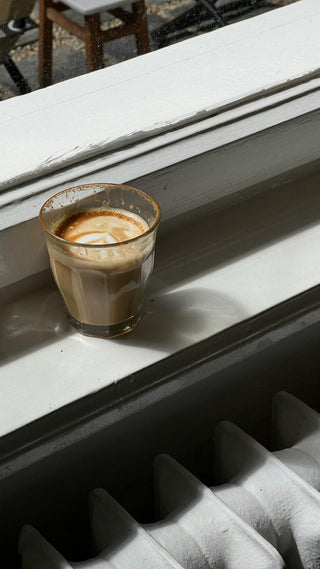 Luluccino Swirl Recipe: Lupine coffee with oat milk standing by a window play of light an shadow