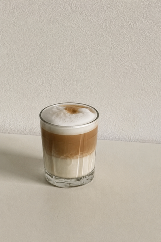 Lulu Lupinenkaffee als cremiger Latte in einem klaren Glas, minimalistisch auf hellem Hintergrund.